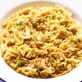 chettinad biryani on a blue rimmed white plate.