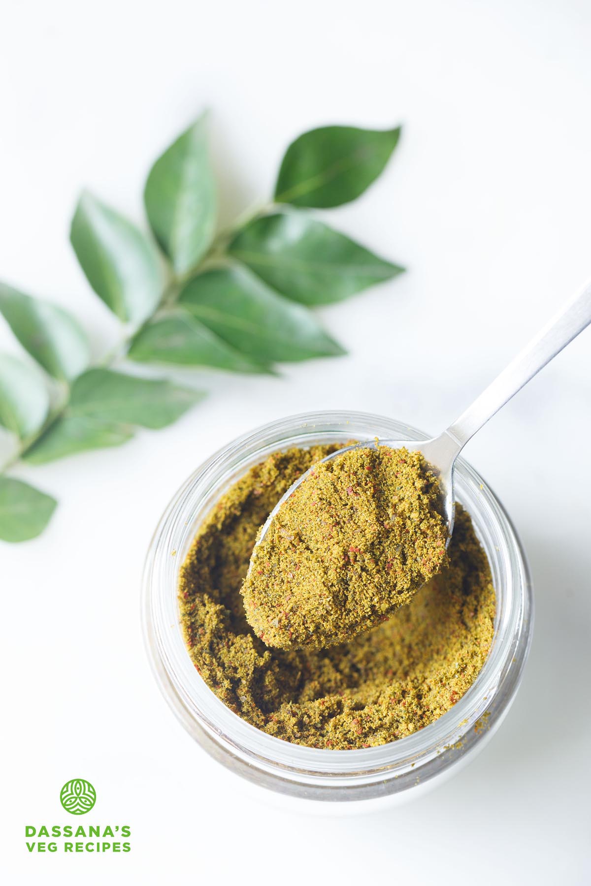 curry leaves powder scooped in a spoon.