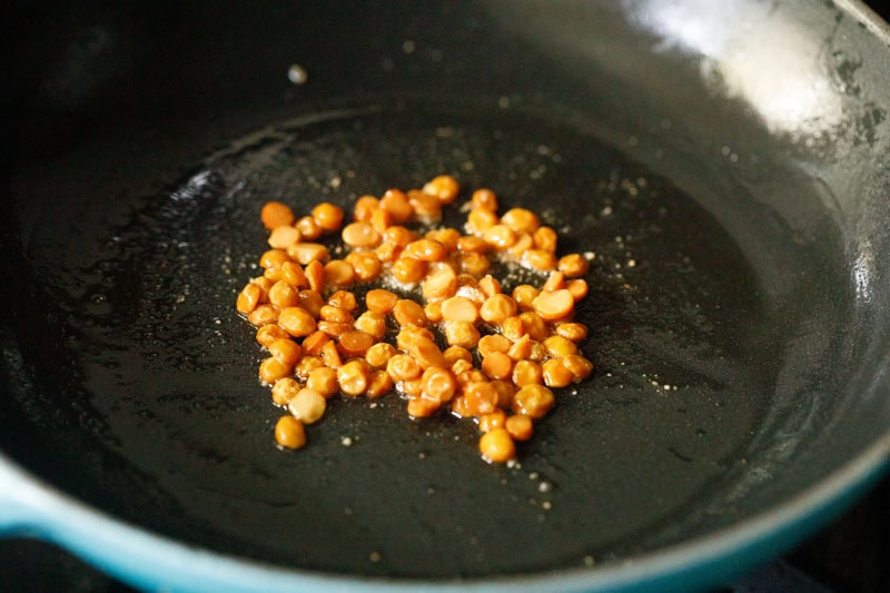 roasted chana dal mixed with hing in skillet.