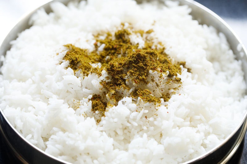 rice fluffed in pan with curry leaves powder sprinkled on top.