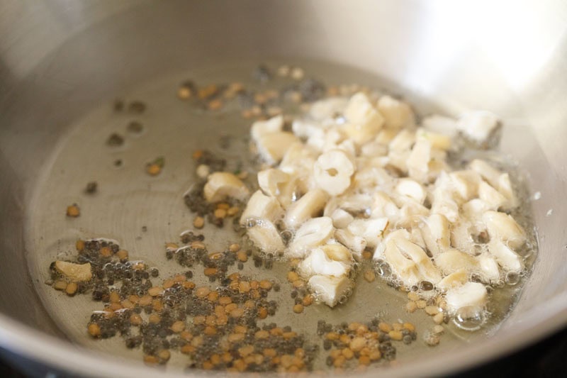 chopped cashews in wok with lightly golden urad dal and crackled mustard seeds.