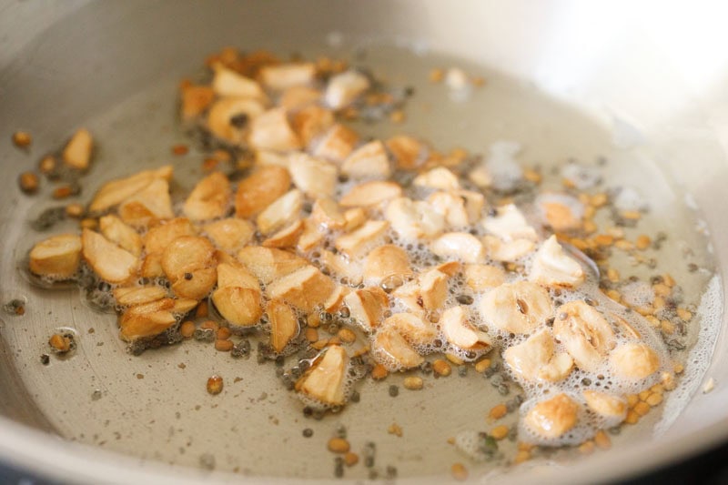 golden cashews with the urad dal and mustard seeds in the kadai.