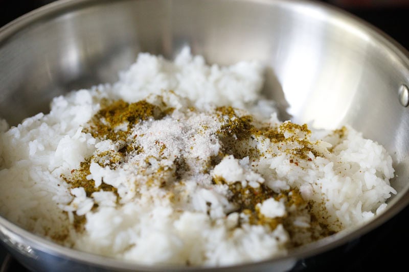 cooked rice, curry leaves powder and salt in the wok.