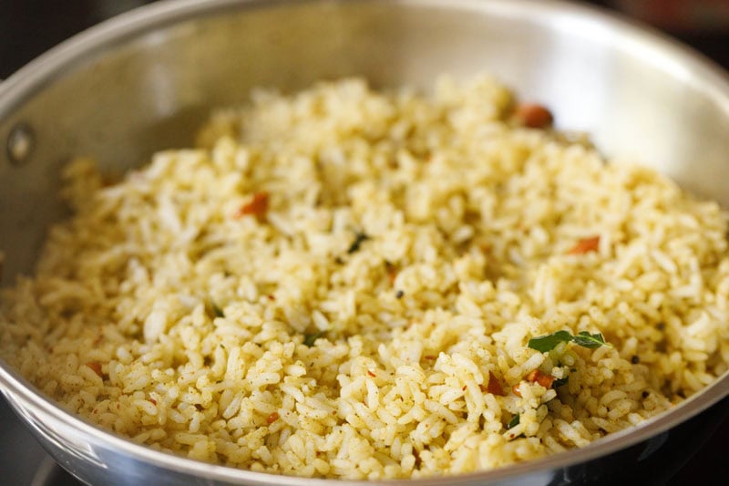 rice mixed evenly with the tempered lentils, spices, curry leaves, cashews, curry leaves powder and salt to make karuveppilai sadam.