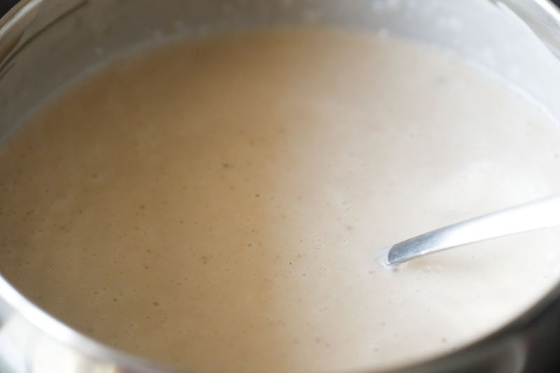 coconut milk mixed with tender coconut mixture with spoon in a bowl to make elaneer payasam.