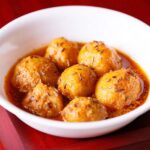 kashmiri dum aloo served in a white bowl.