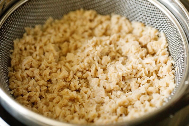 strained soya granules in a strainer.