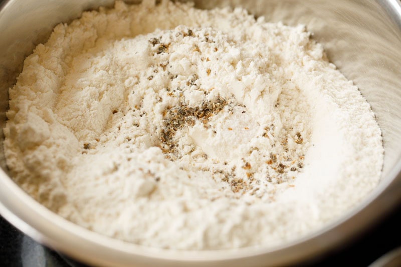 flour with cardamom powder and salt in a mixing bowl for making shirmal. 