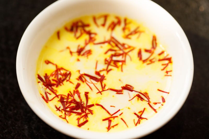 saffron added to warm milk in a bowl. 