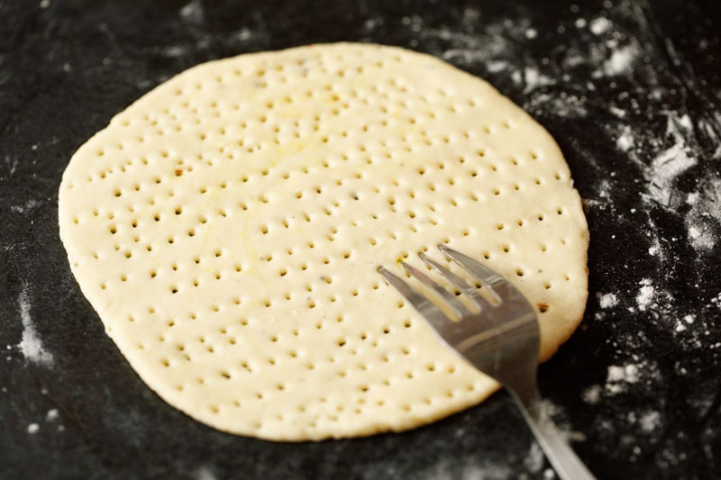 rolled sheermal roti being poked by fork.