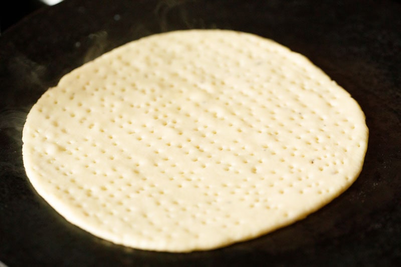 poked dough disc on a hot tawa or flat skillet.