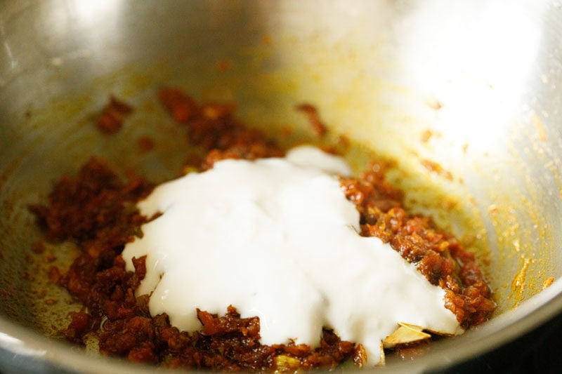 a layer of curd (yogurt) on top of the sautéed onion-tomato masala.