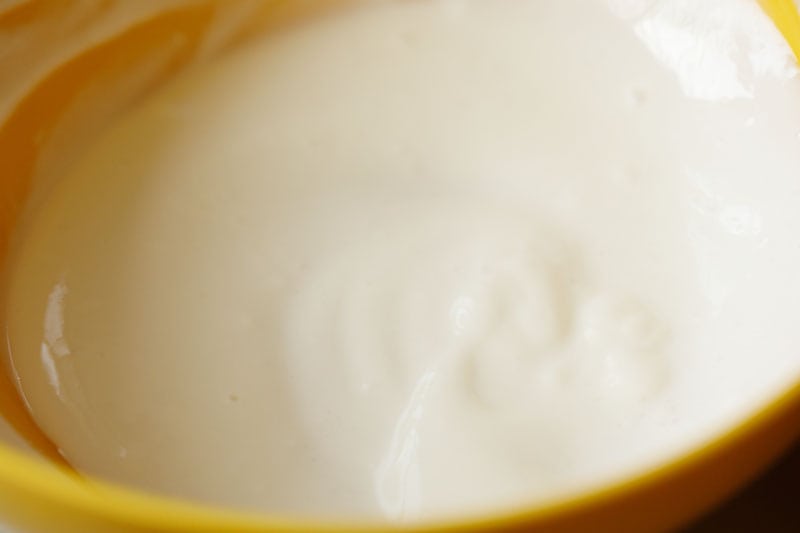 whisked or beaten curd in a bowl.