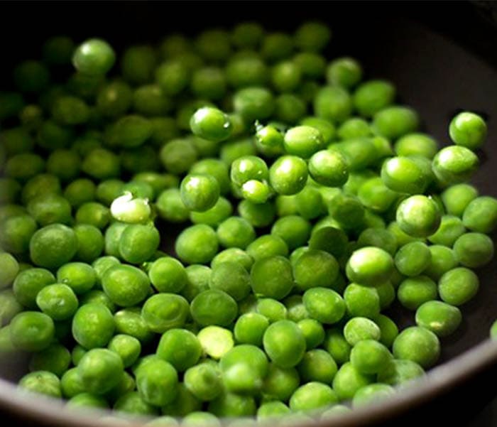 green peas cooking in a pan.