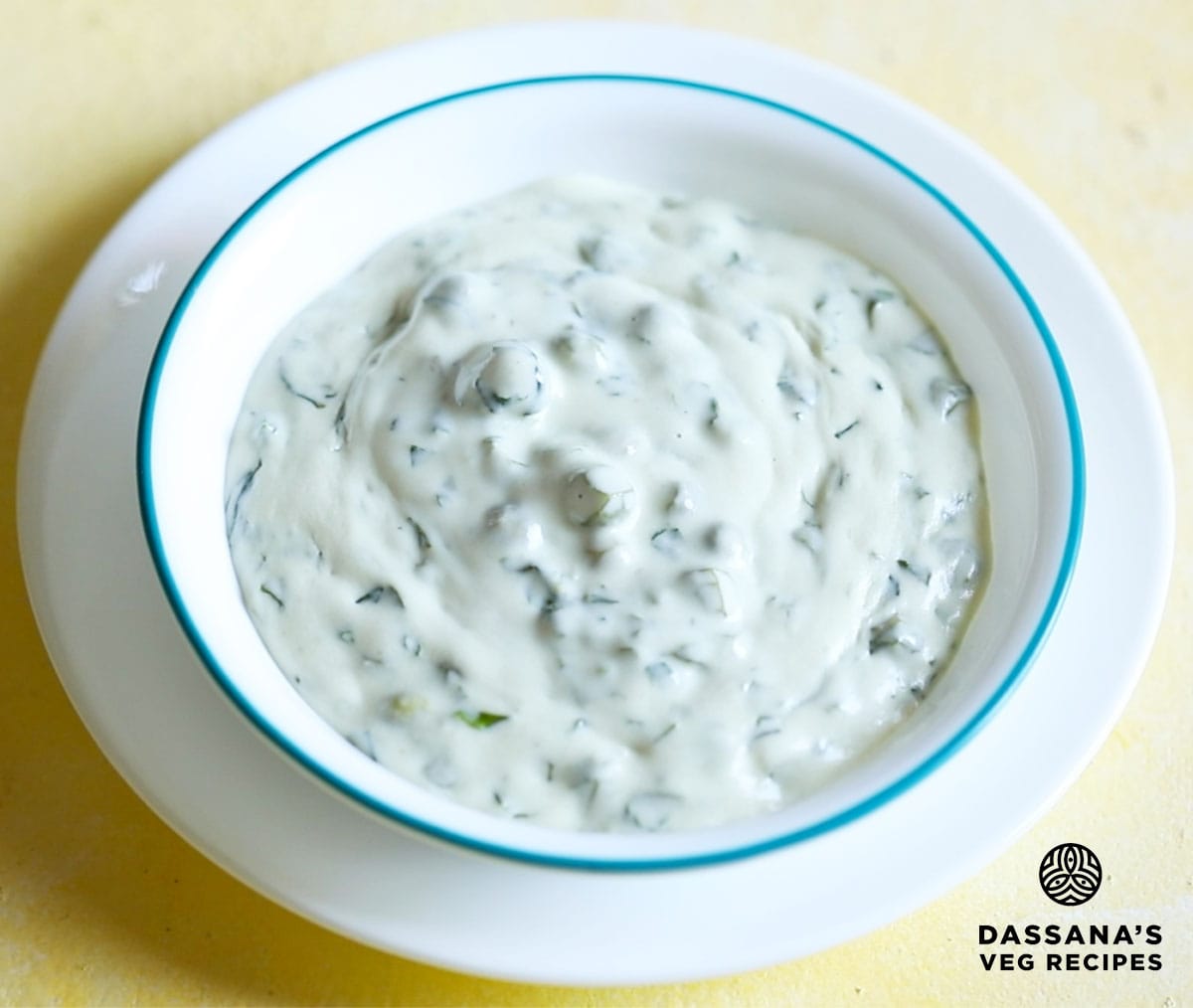 methi matar malai in a white bowl with a light blue rim.