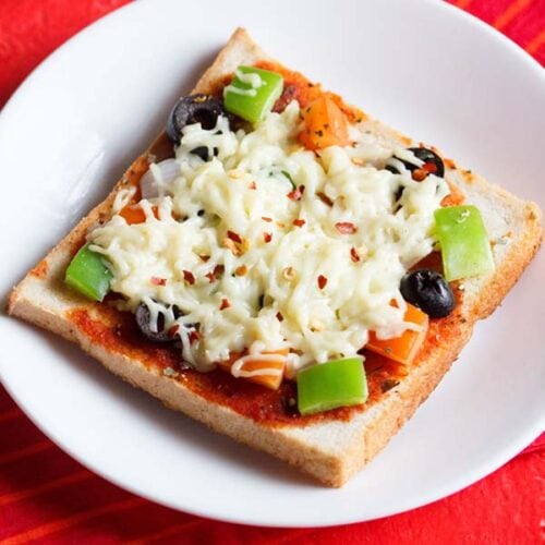 bread pizza slice on a white table with a red cloth underneath.