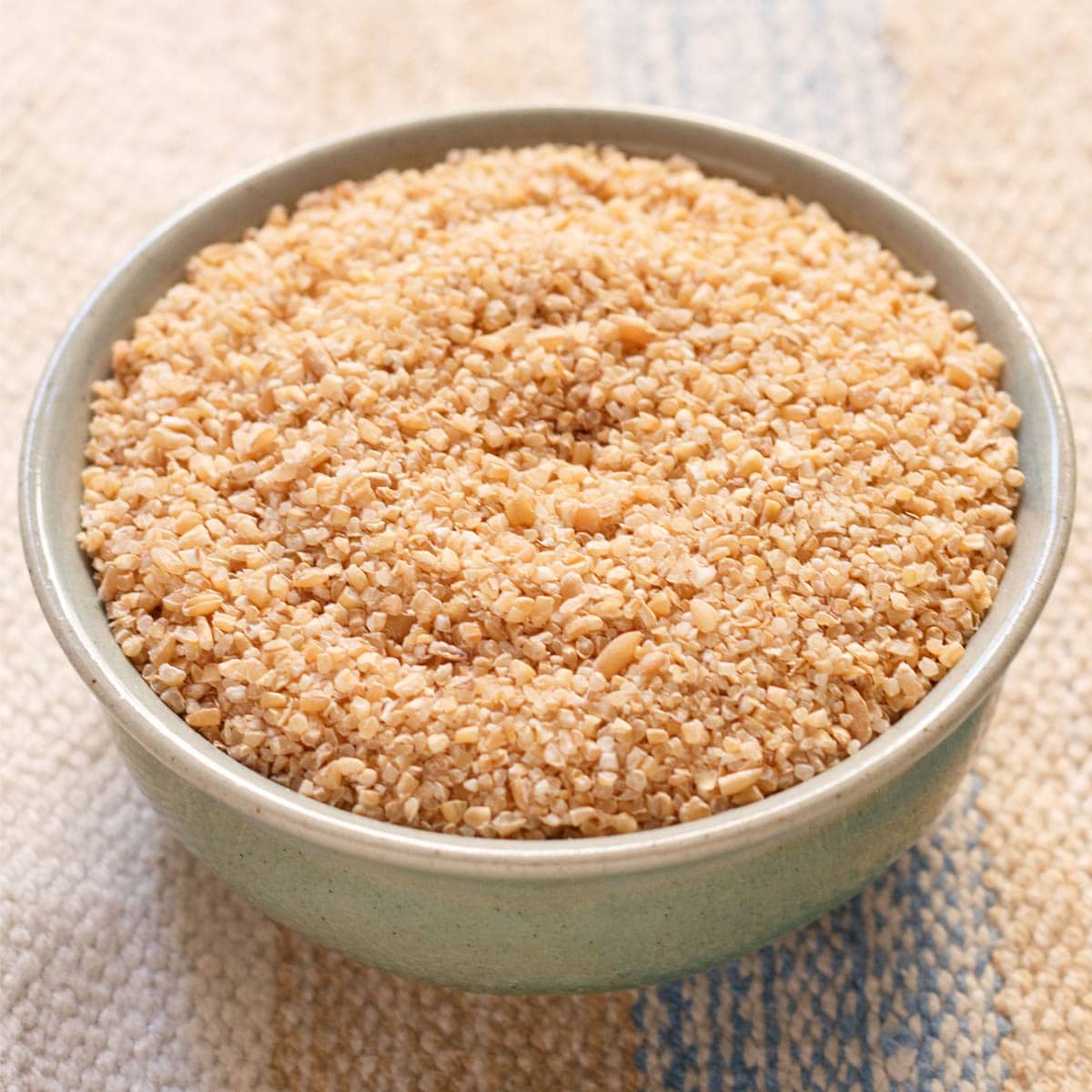 daliya (broken wheat or cracked wheat) in a ceramic bowl.