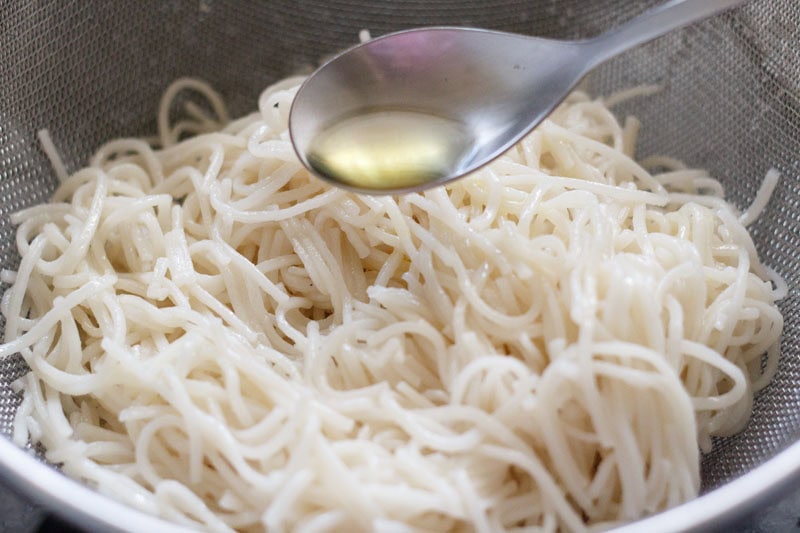 adding toasted sesame oil to cooked and drained noodles. 