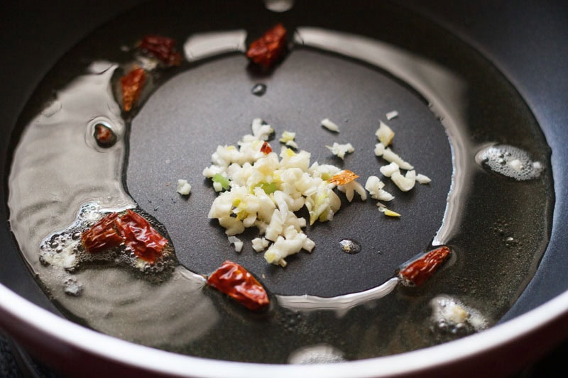 dried red chilies and finely chopped garlic added to hot sunflower oil in pan. 