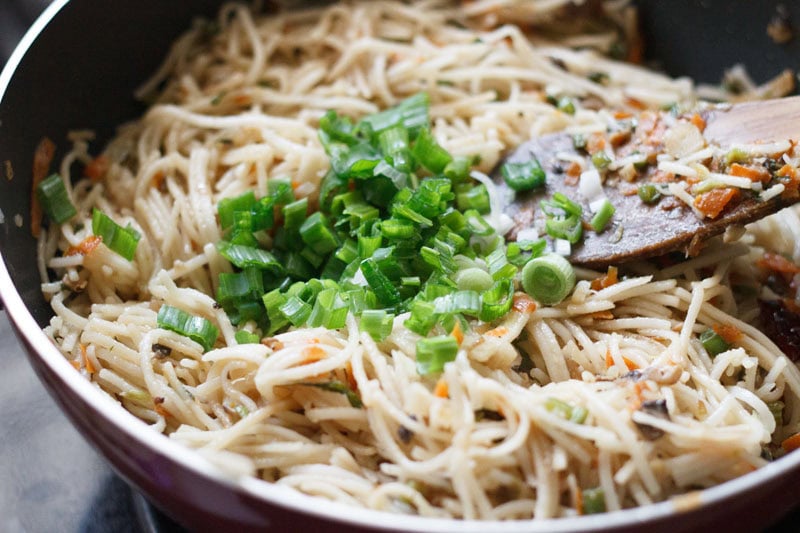 chopped spring onion greens added to cooked hakka noodles.