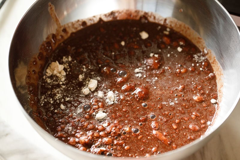 adding cocoa solution to flour mixture for eggless brownie. 